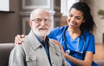 young-nurse-in-blue-coat-hugging-old-80s-man-smili-2025-01-09-03-16-30-utc